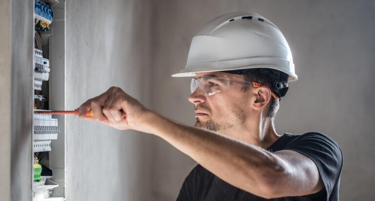 A qualified electrician inspecting or repairing a switchboard, power point, or lighting system inside a modern home.